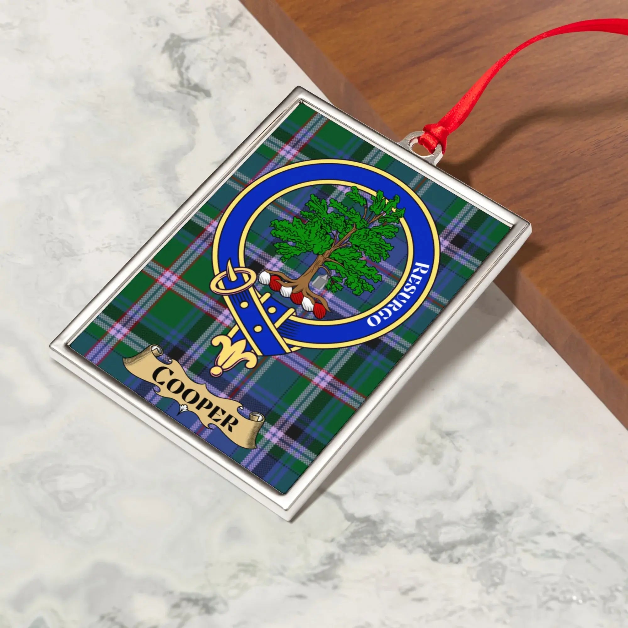 Cooper ornament hanging from a Christmas tree branch by its satin ribbon