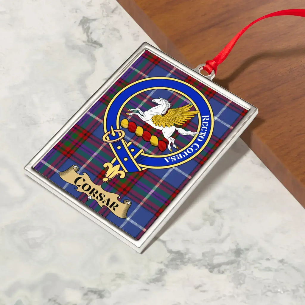 Corsar ornament hanging from a Christmas tree branch by its satin ribbon