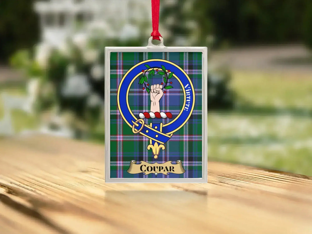 Close-up of the Coupar family crest on a polished silver-frame metal ornament