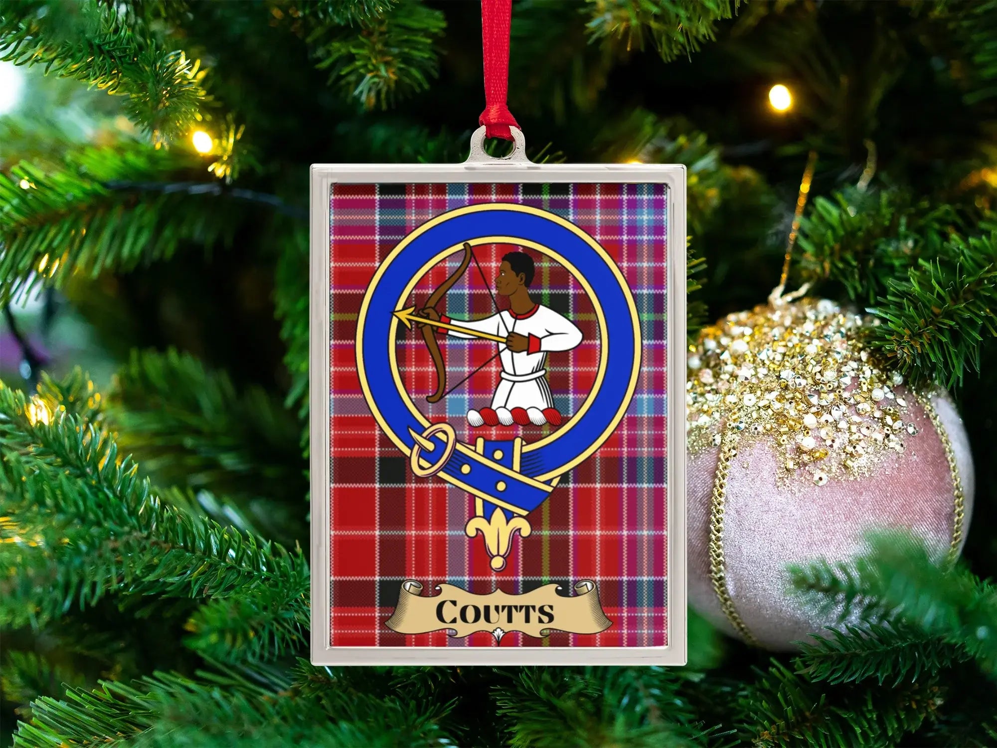 Coutts clan crest Christmas ornament in a silver frame on a tartan background