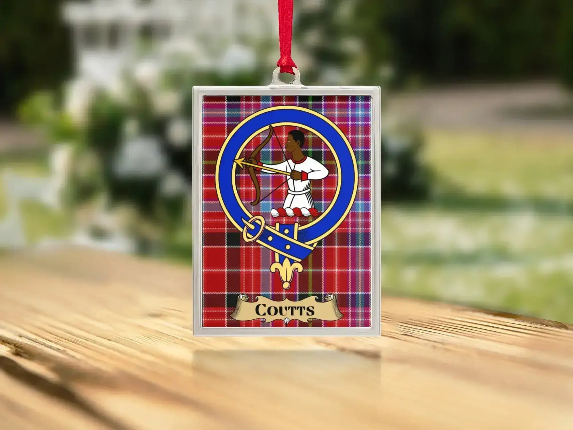 Close-up of the Coutts family crest on a polished silver-frame metal ornament
