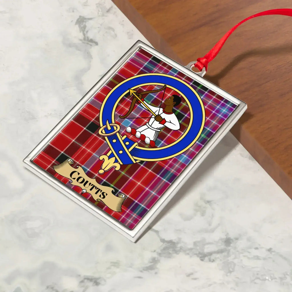 Coutts ornament hanging from a Christmas tree branch by its satin ribbon