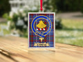 Close-up of the Cowan family crest on a polished silver-frame metal ornament