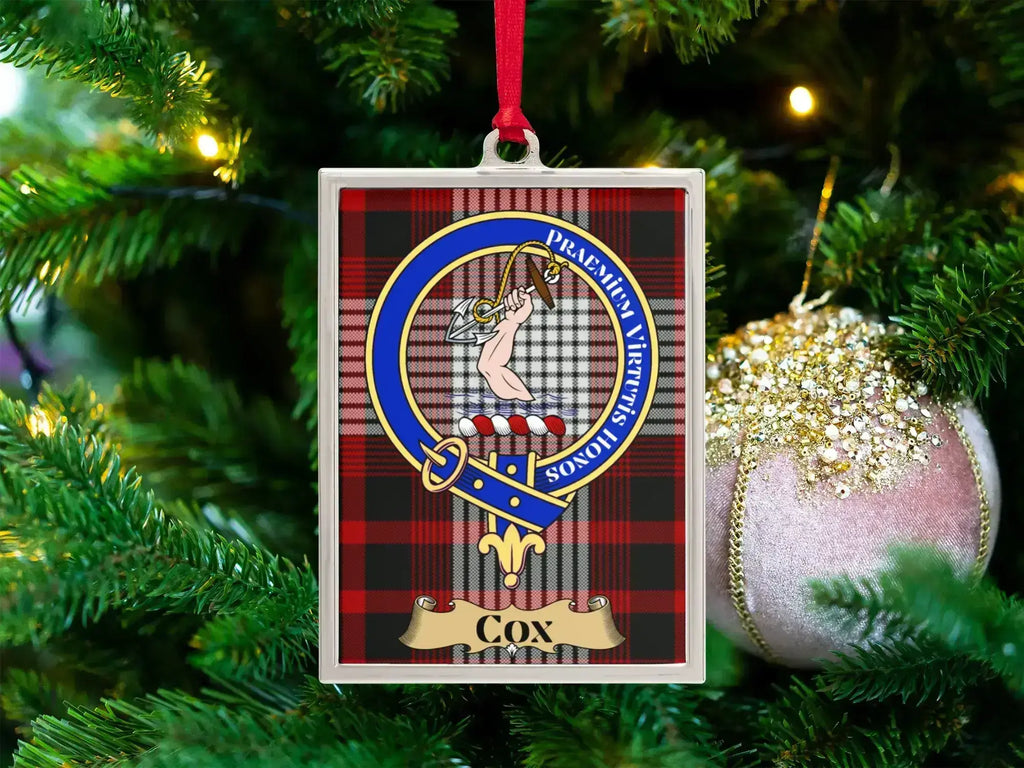 Cox clan crest Christmas ornament in a silver frame on a tartan background
