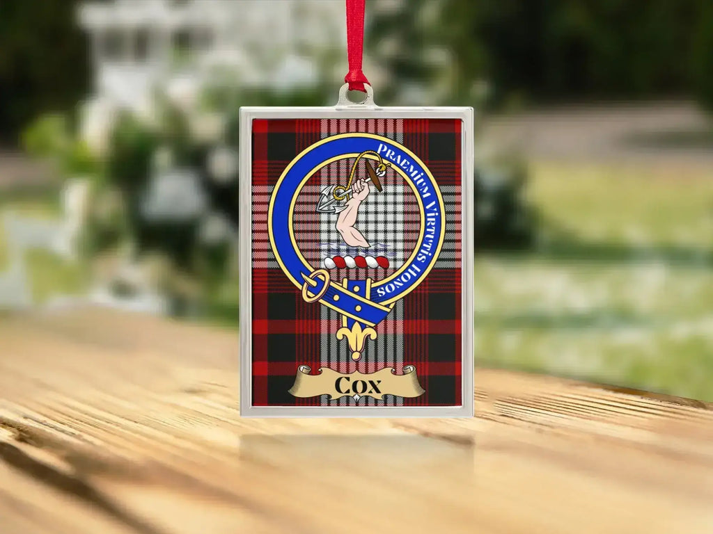 Close-up of the Cox family crest on a polished silver-frame metal ornament