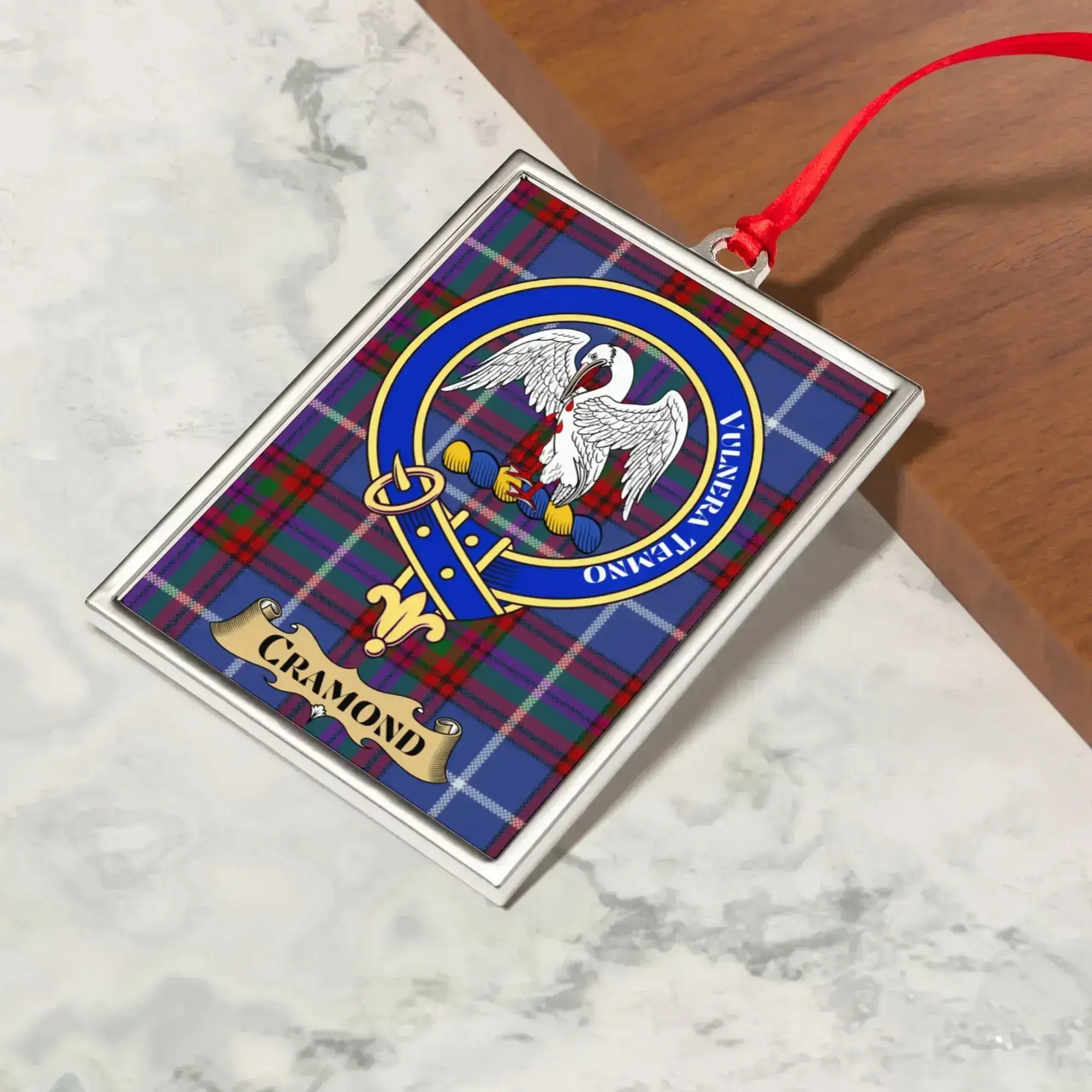 Cramond ornament hanging from a Christmas tree branch by its satin ribbon