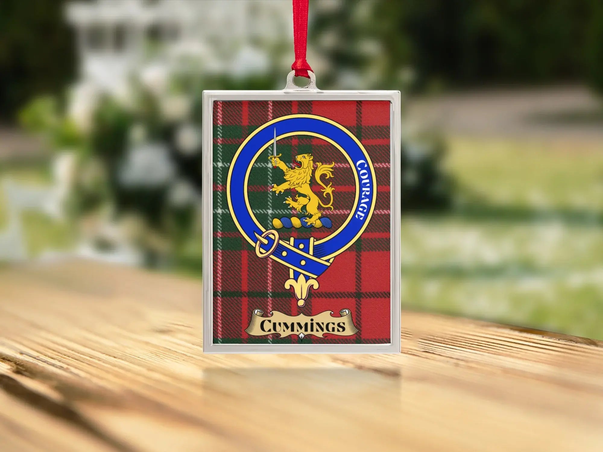 Close-up of the Cummings family crest on a polished silver-frame metal ornament