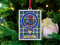 Currell clan crest Christmas ornament in a silver frame on a tartan background