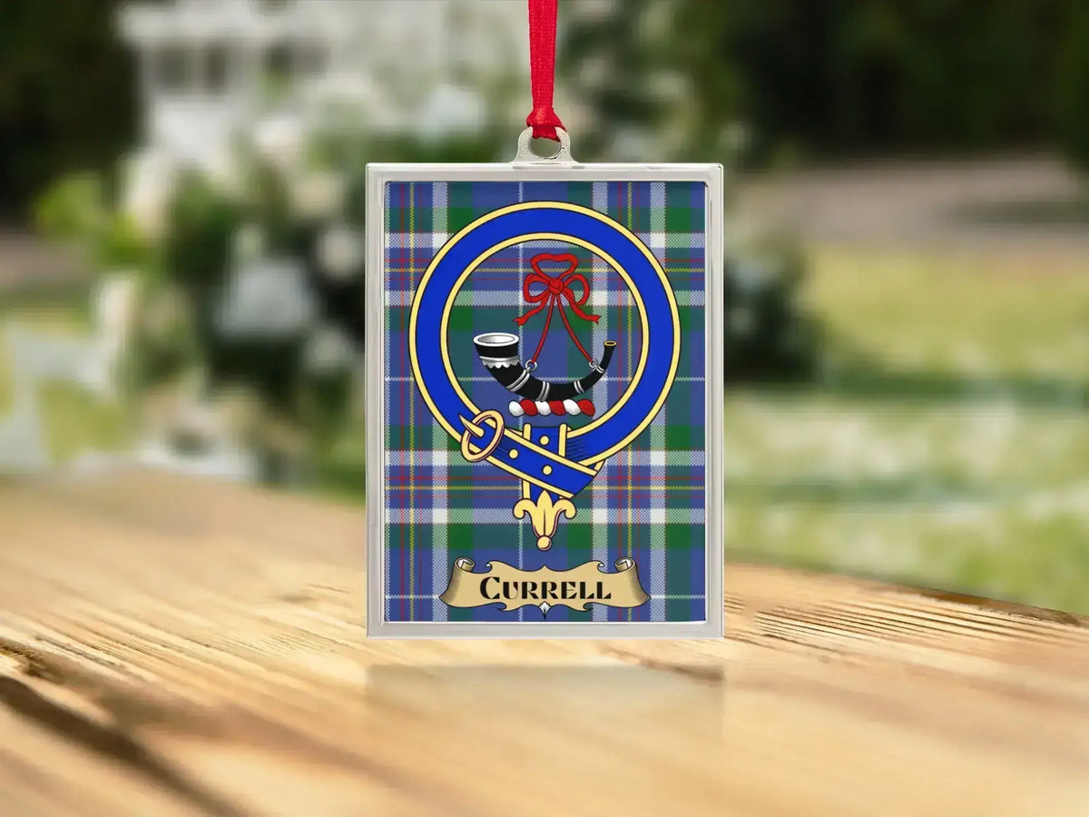 Close-up of the Currell family crest on a polished silver-frame metal ornament