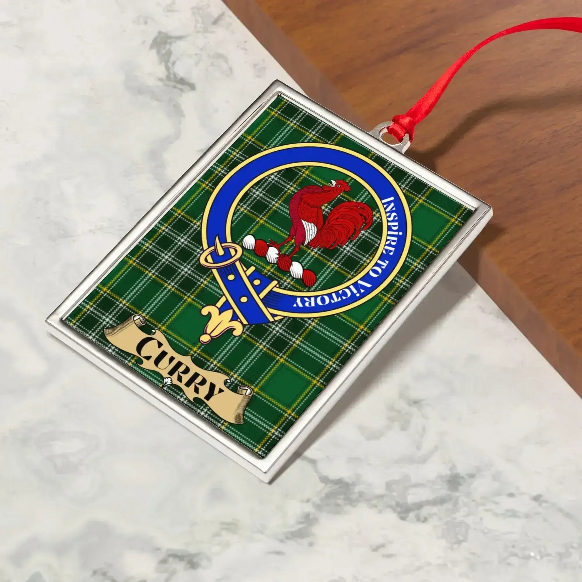 Curry ornament hanging from a Christmas tree branch by its satin ribbon
