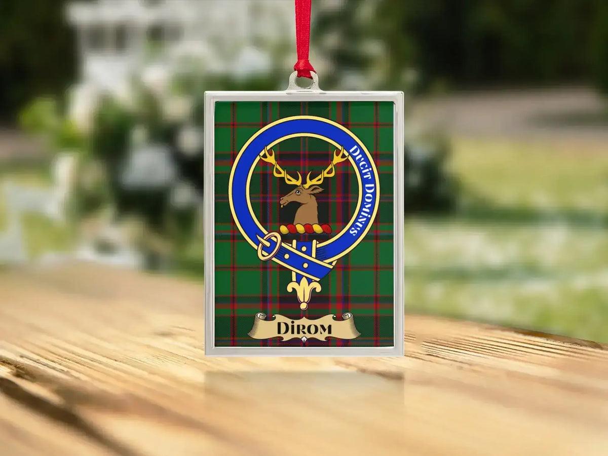 Close-up of the Dirom family crest on a polished silver-frame metal ornament