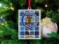 Dobbie clan crest Christmas ornament in a silver frame on a tartan background