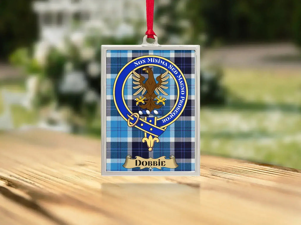 Close-up of the Dobbie family crest on a polished silver-frame metal ornament