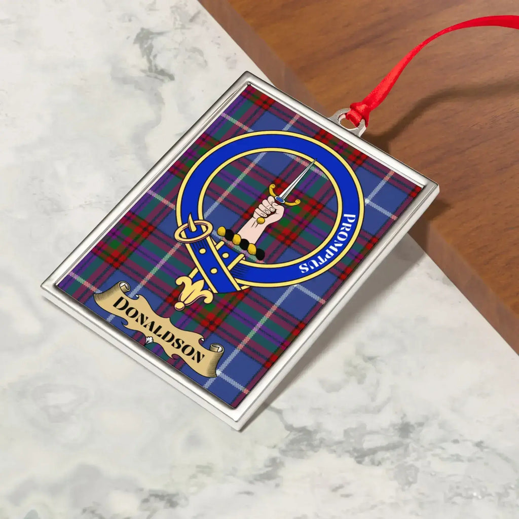 Donaldson ornament hanging from a Christmas tree branch by its satin ribbon