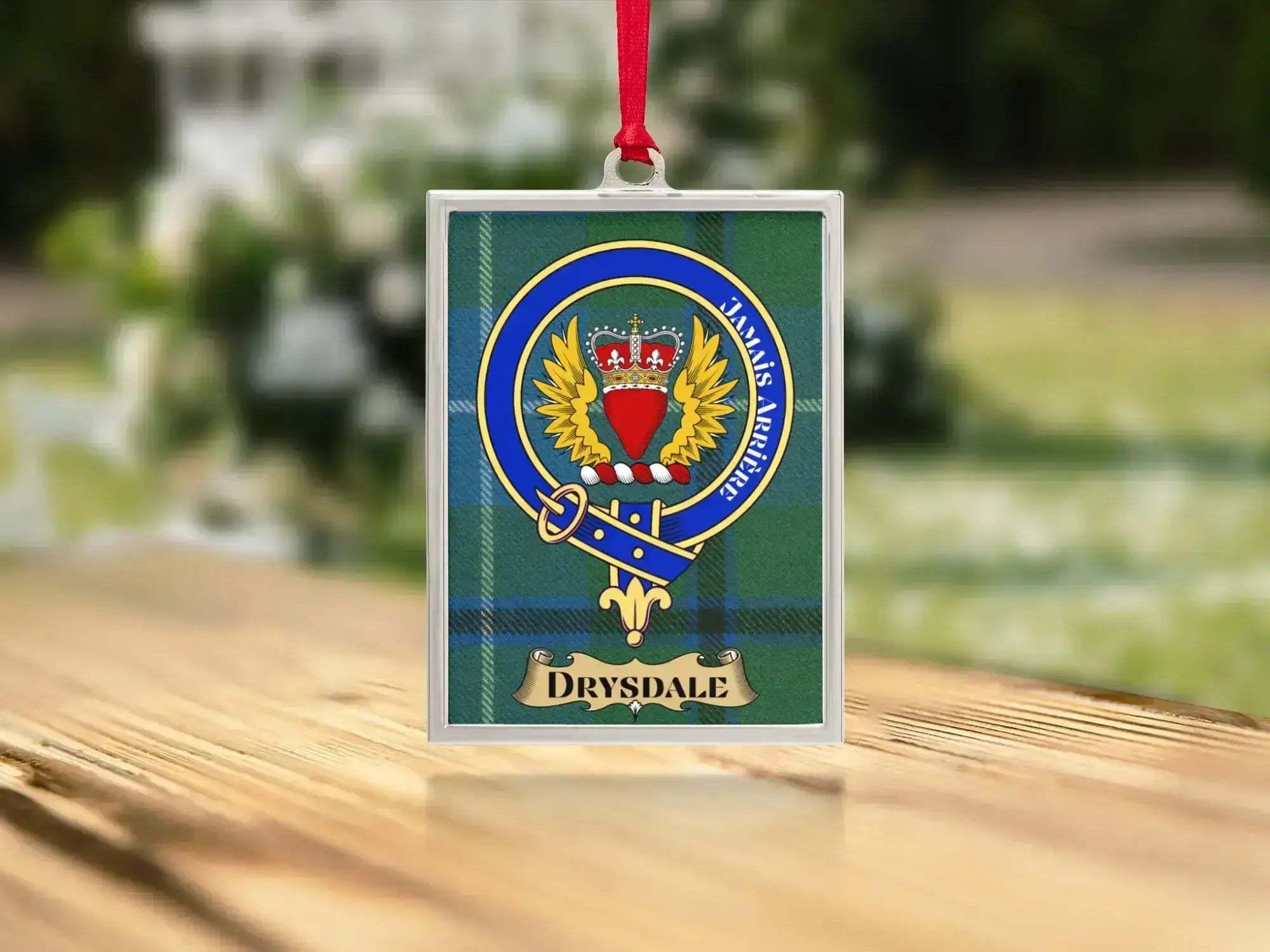 Close-up of the Drysdale family crest on a polished silver-frame metal ornament