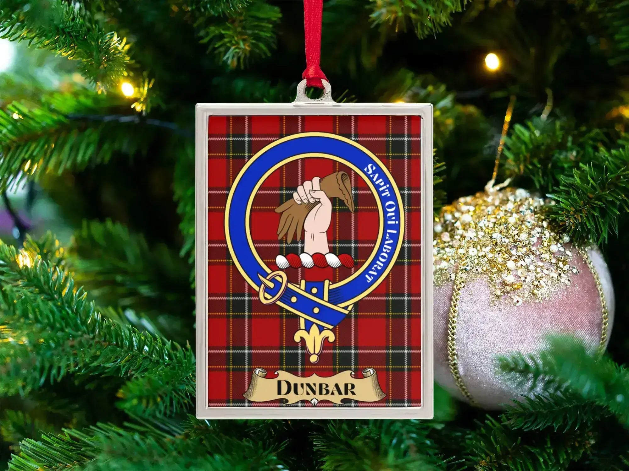 Dunbar clan crest Christmas ornament in a silver frame on a tartan background