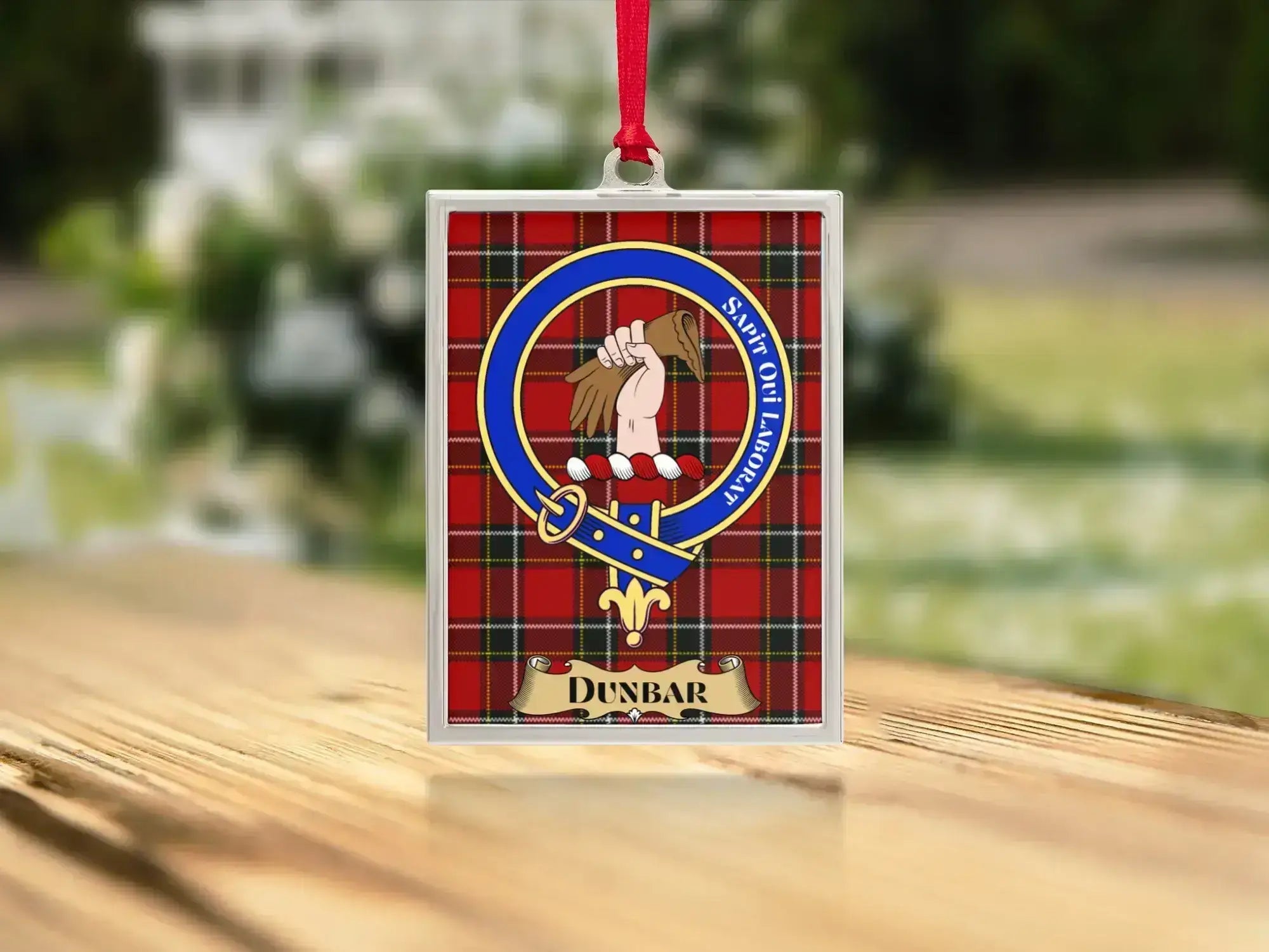 Close-up of the Dunbar family crest on a polished silver-frame metal ornament