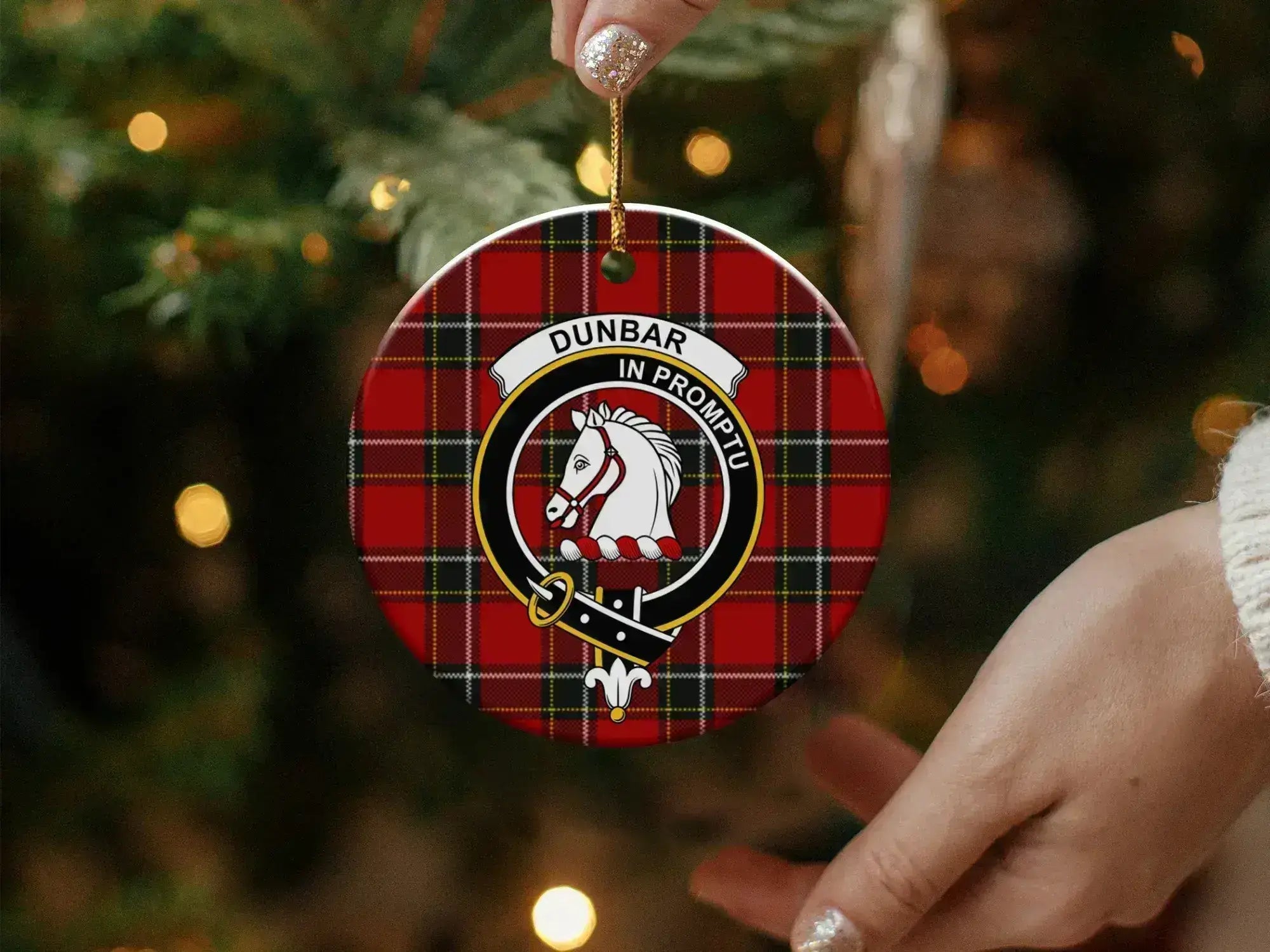 Dunbar clan ornament angled view — 3 inch round ceramic, gold string, crest on tartan background