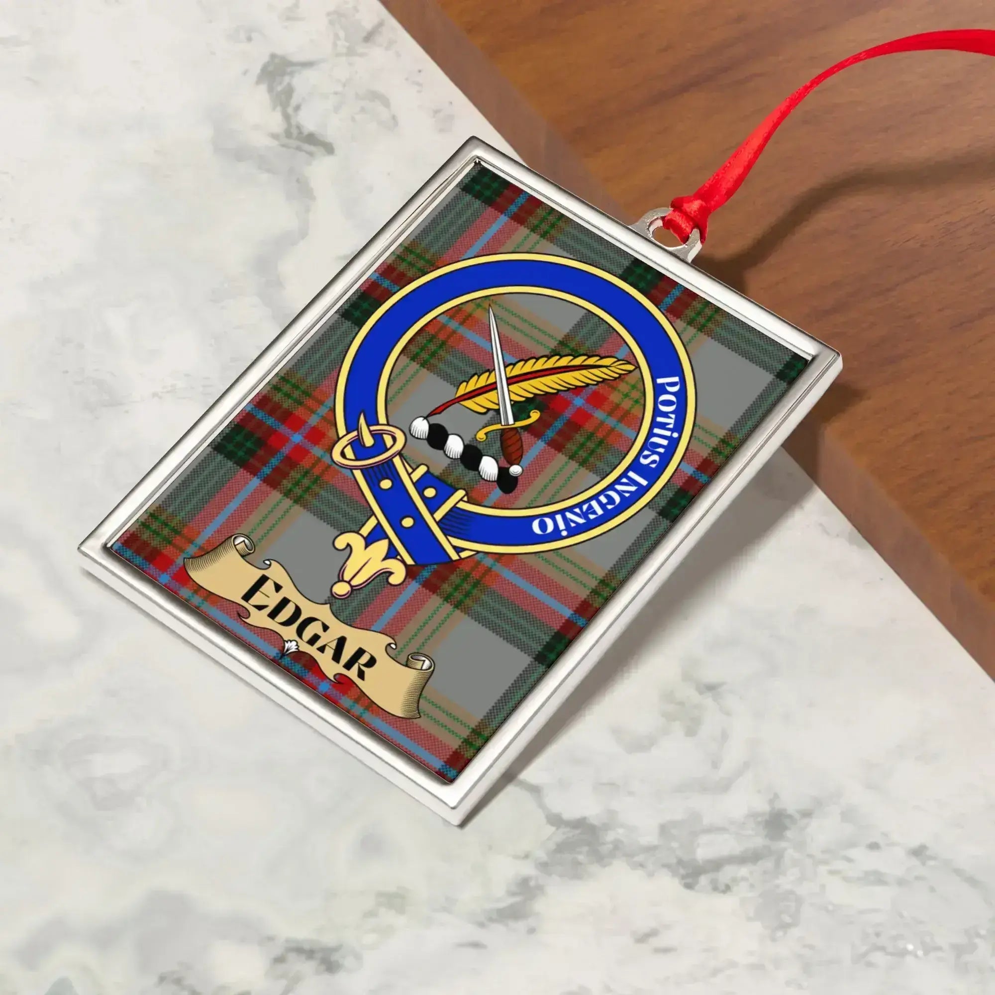 Edgar ornament hanging from a Christmas tree branch by its satin ribbon