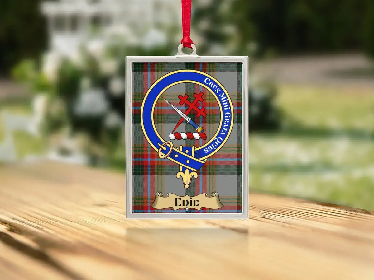 Close-up of the Edie family crest on a polished silver-frame metal ornament