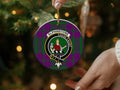Elphinstone clan ornament angled view — 3 inch round ceramic, gold string, crest on tartan background