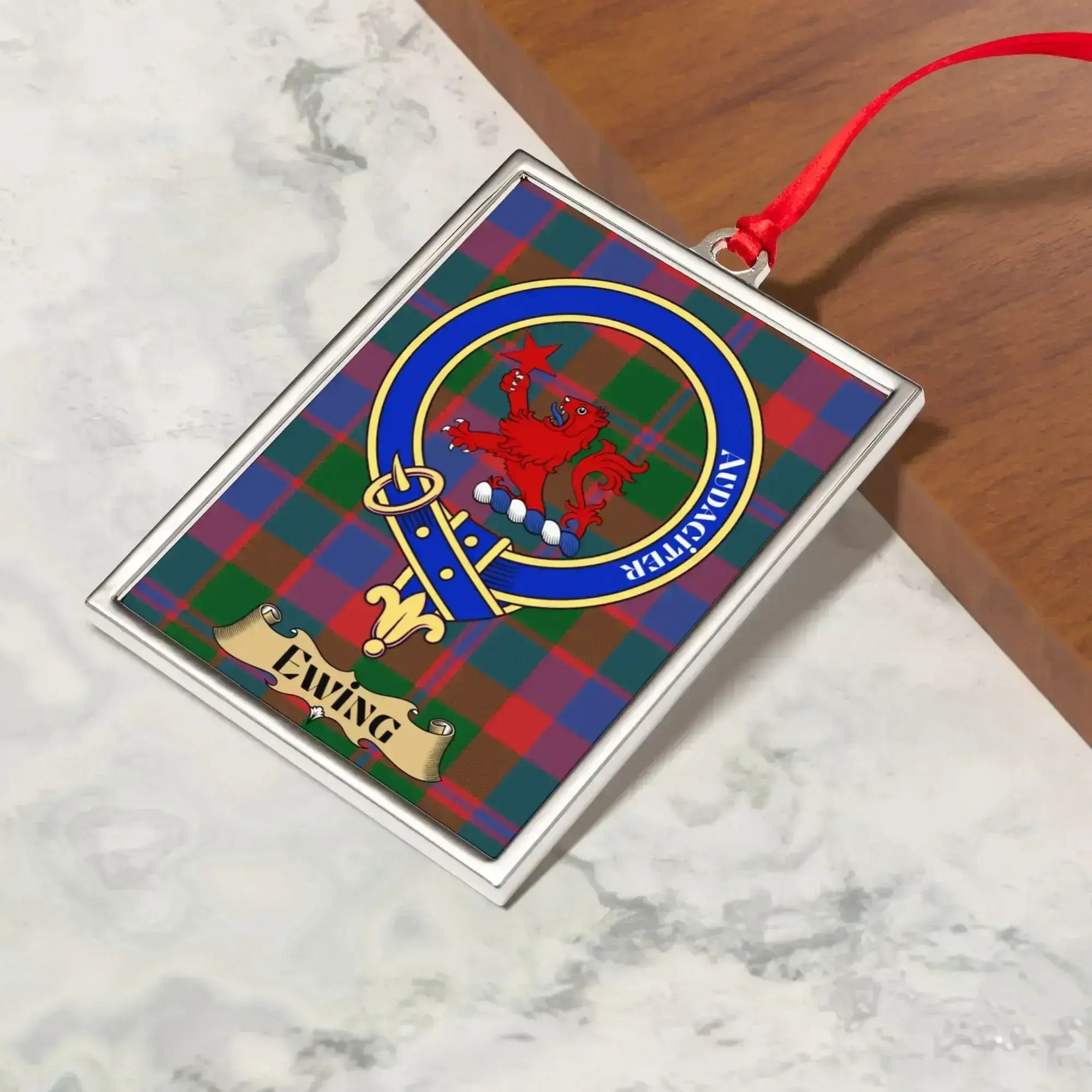 Ewing ornament hanging from a Christmas tree branch by its satin ribbon