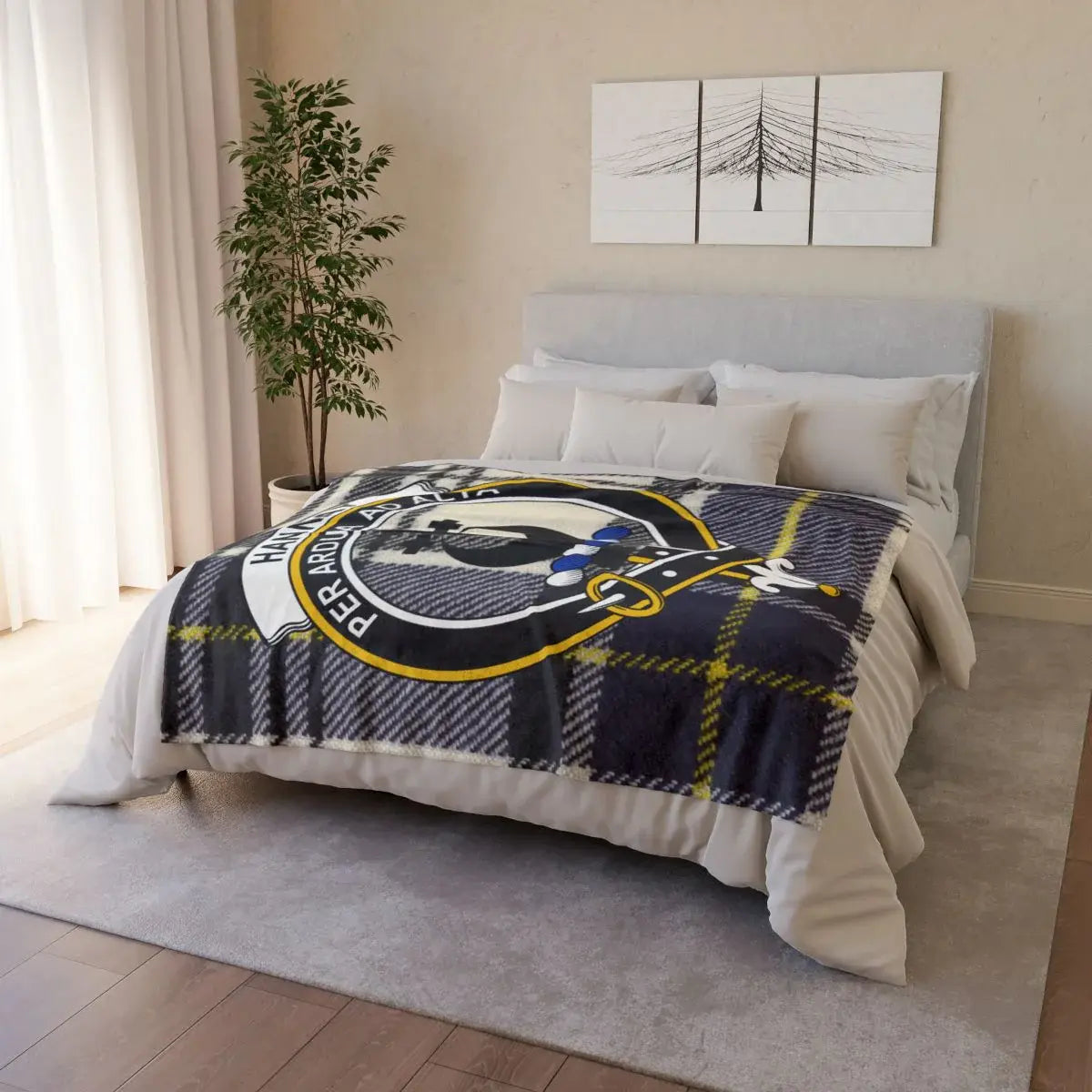 Hannay clan crest throw blanket — draped over sofa showing printed tartan and crest on front