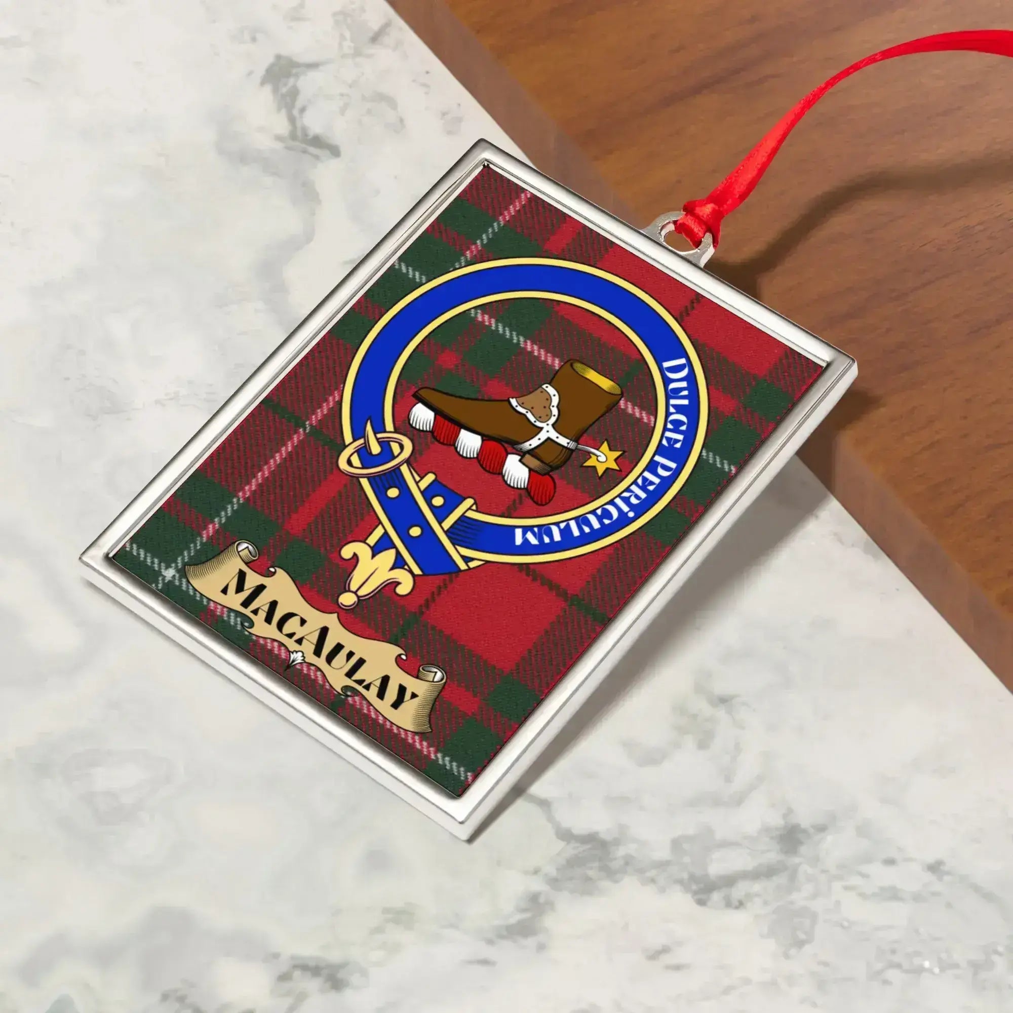 MacAulay ornament hanging from a Christmas tree branch by its satin ribbon