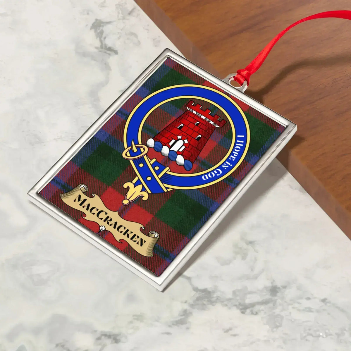MacCracken ornament hanging from a Christmas tree branch by its satin ribbon