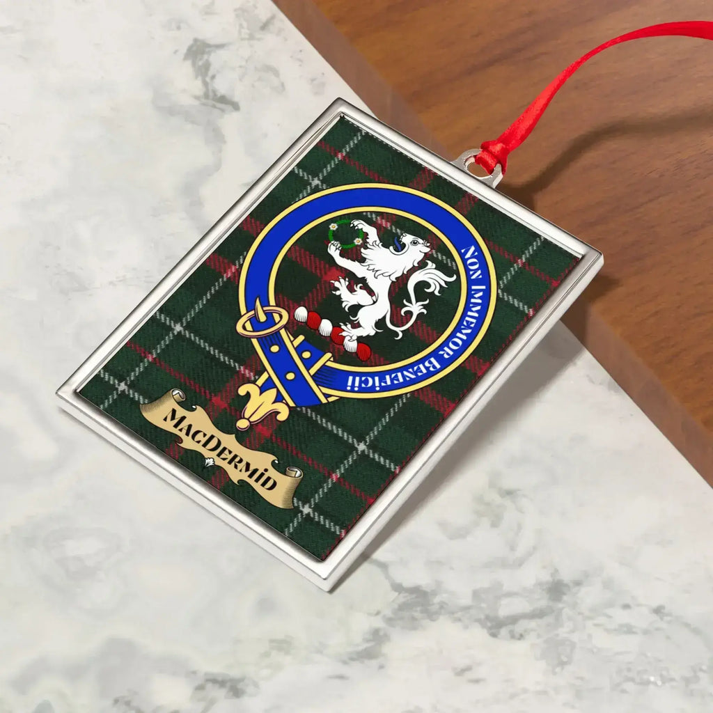 MacDermid ornament hanging from a Christmas tree branch by its satin ribbon