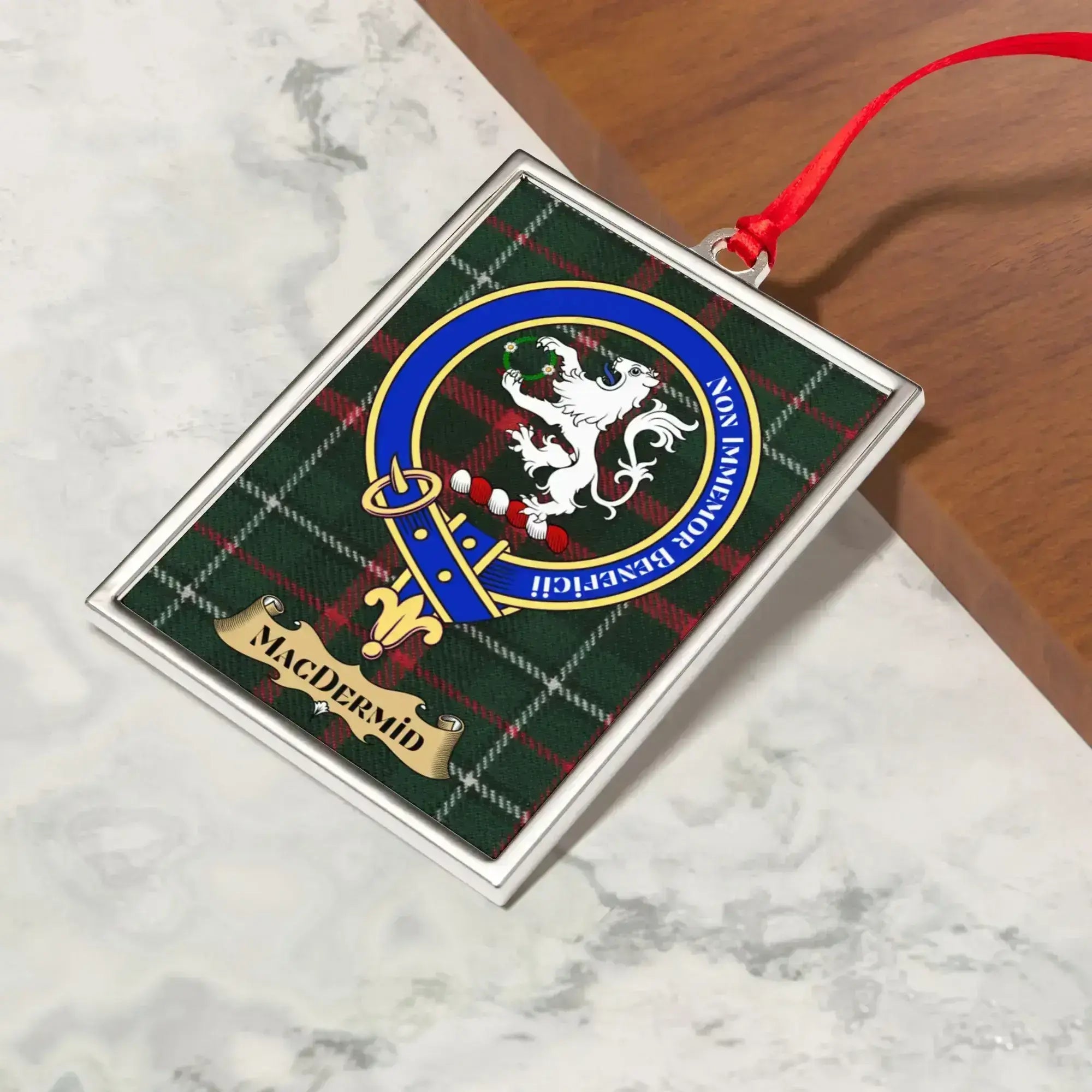 MacDermid ornament hanging from a Christmas tree branch by its satin ribbon