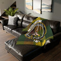 Clan MacMillan crest tartan printed throw blanket — green and yellow clan colours on sofa