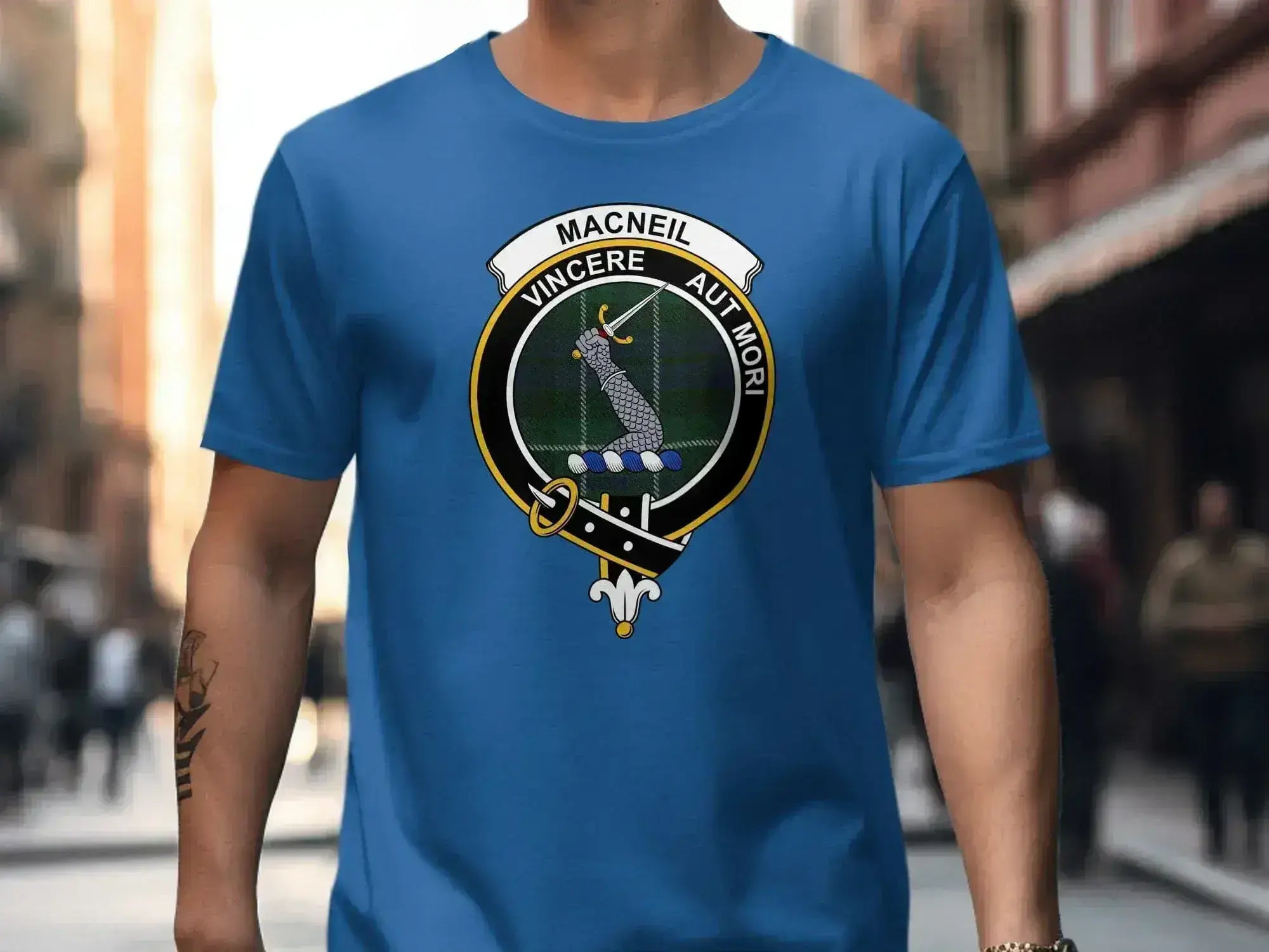 MacNeil clan tartan t-shirt shown on model — unisex fit with printed crest in royal blue
