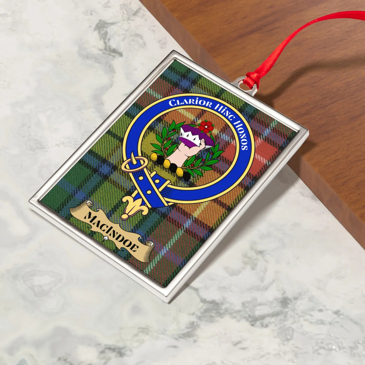 Macindoe ornament hanging from a Christmas tree branch by its satin ribbon