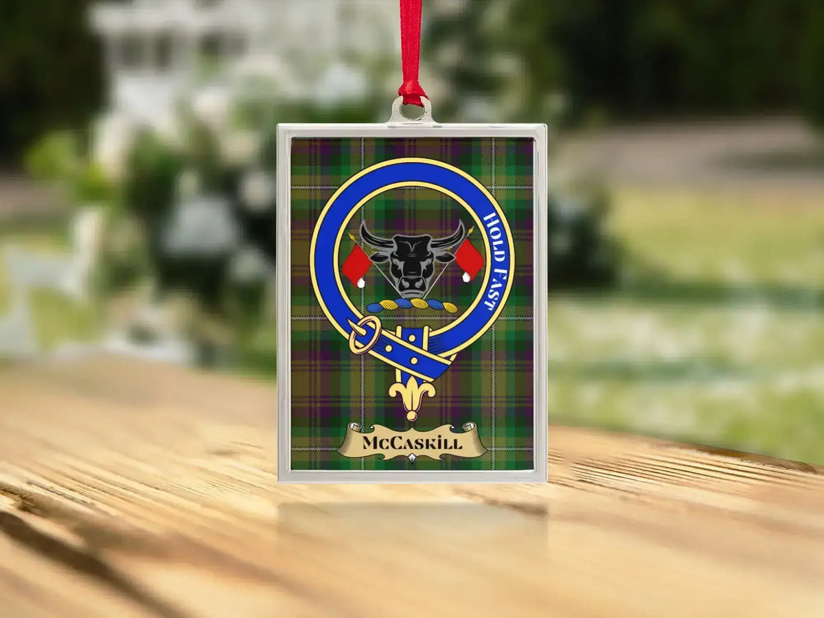 Close-up of the McCaskill family crest on a polished silver-frame metal ornament