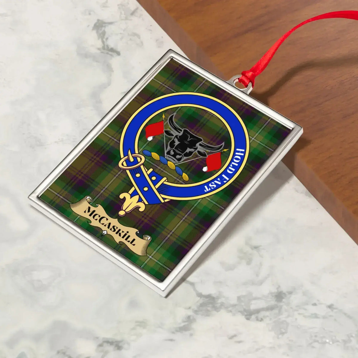 McCaskill ornament hanging from a Christmas tree branch by its satin ribbon