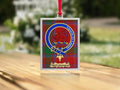 Close-up of the McClintock family crest on a polished silver-frame metal ornament