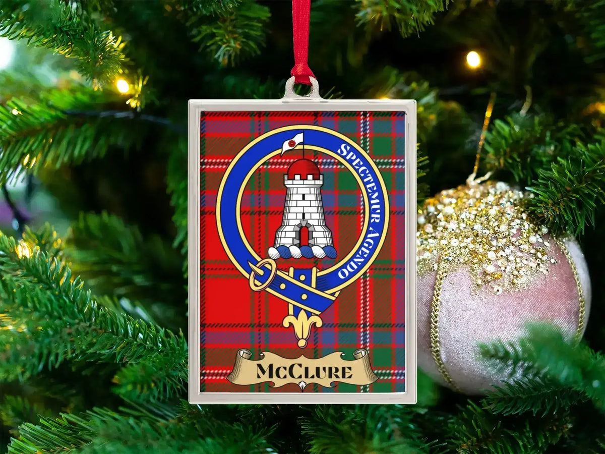 McClure clan crest Christmas ornament in a silver frame on a tartan background
