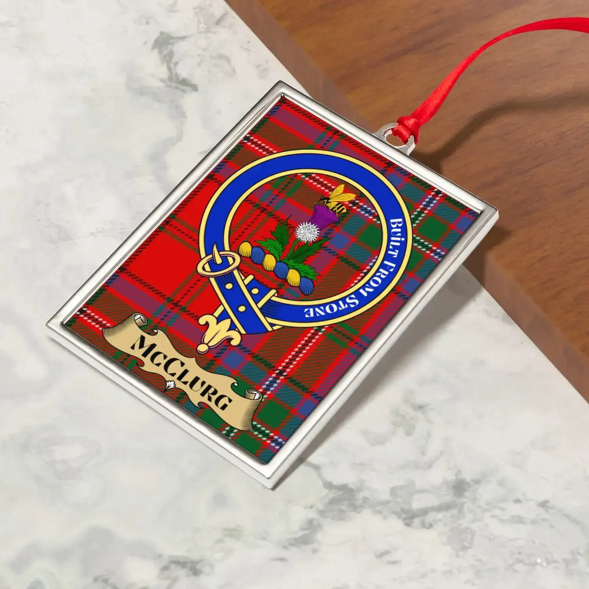 McClurg ornament hanging from a Christmas tree branch by its satin ribbon