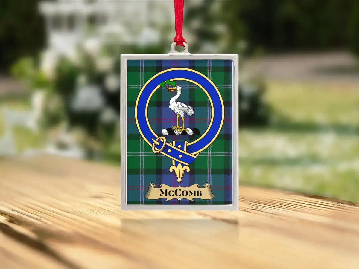 Close-up of the McComb family crest on a polished silver-frame metal ornament