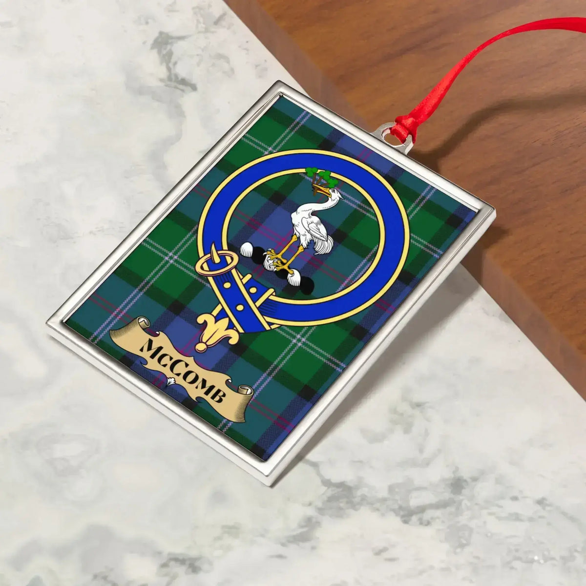 McComb ornament hanging from a Christmas tree branch by its satin ribbon