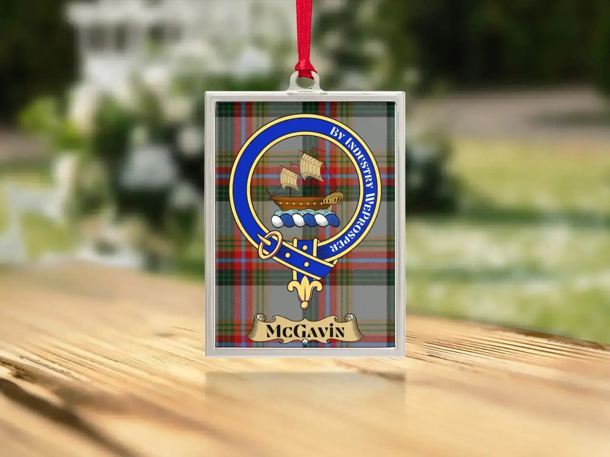 Close-up of the McGavin family crest on a polished silver-frame metal ornament