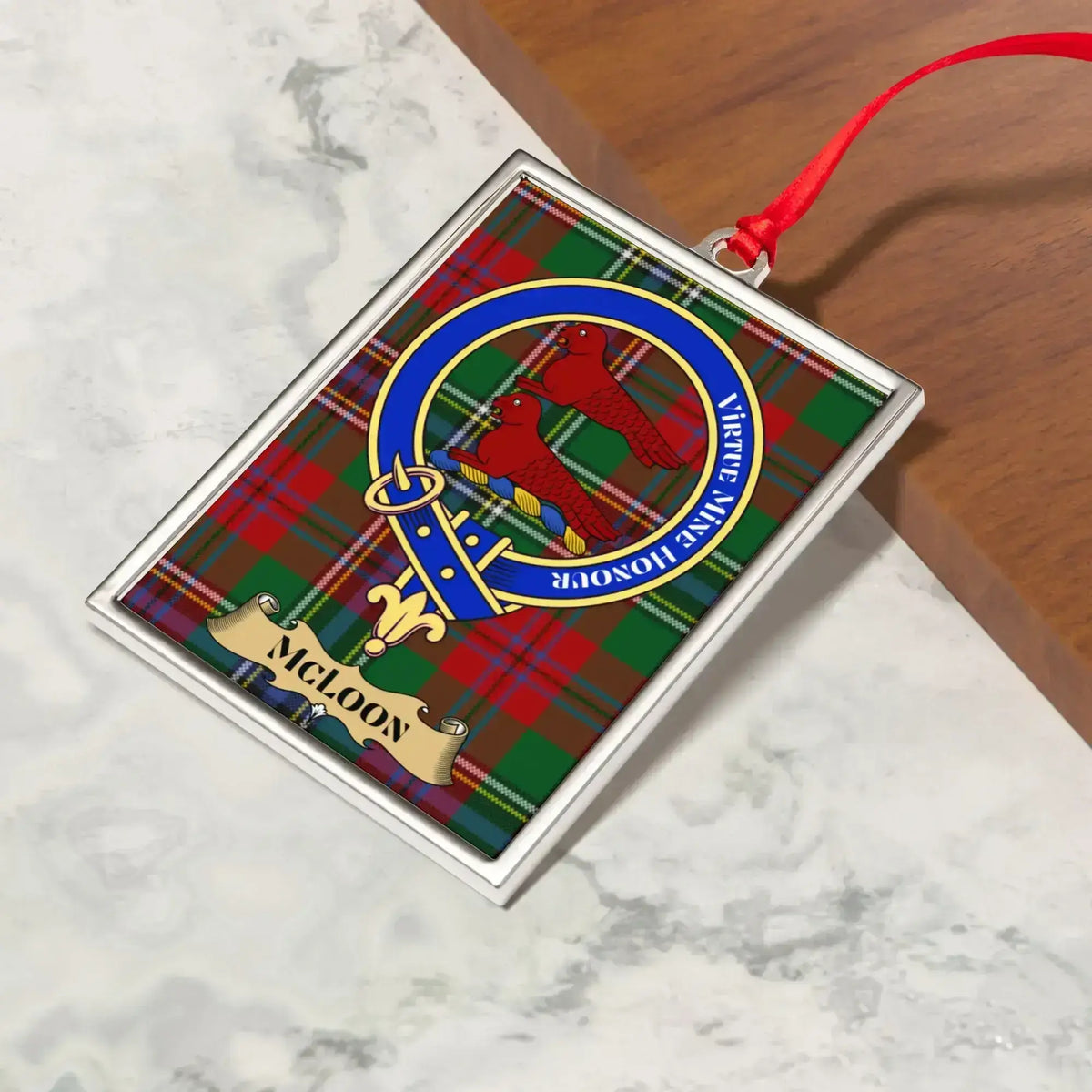 McLoon ornament hanging from a Christmas tree branch by its satin ribbon