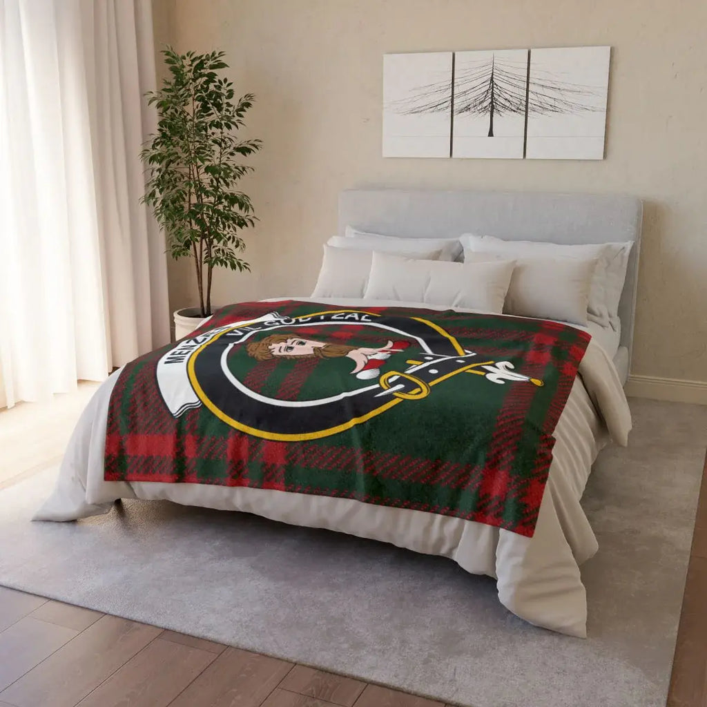 Menzies clan crest tartan throw blanket on bed — printed polyester with white reverse and hemmed edges