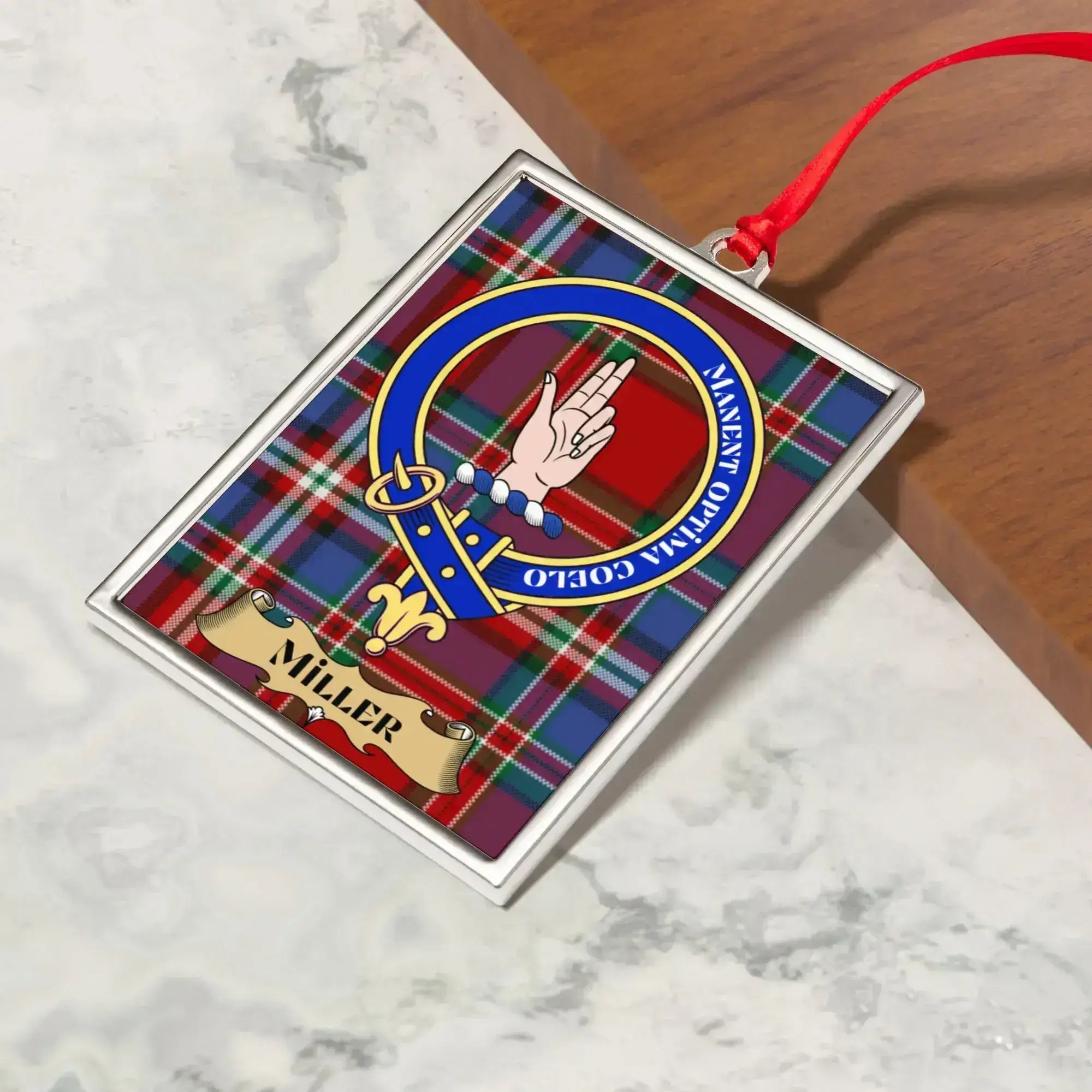 Miller ornament hanging from a Christmas tree branch by its satin ribbon