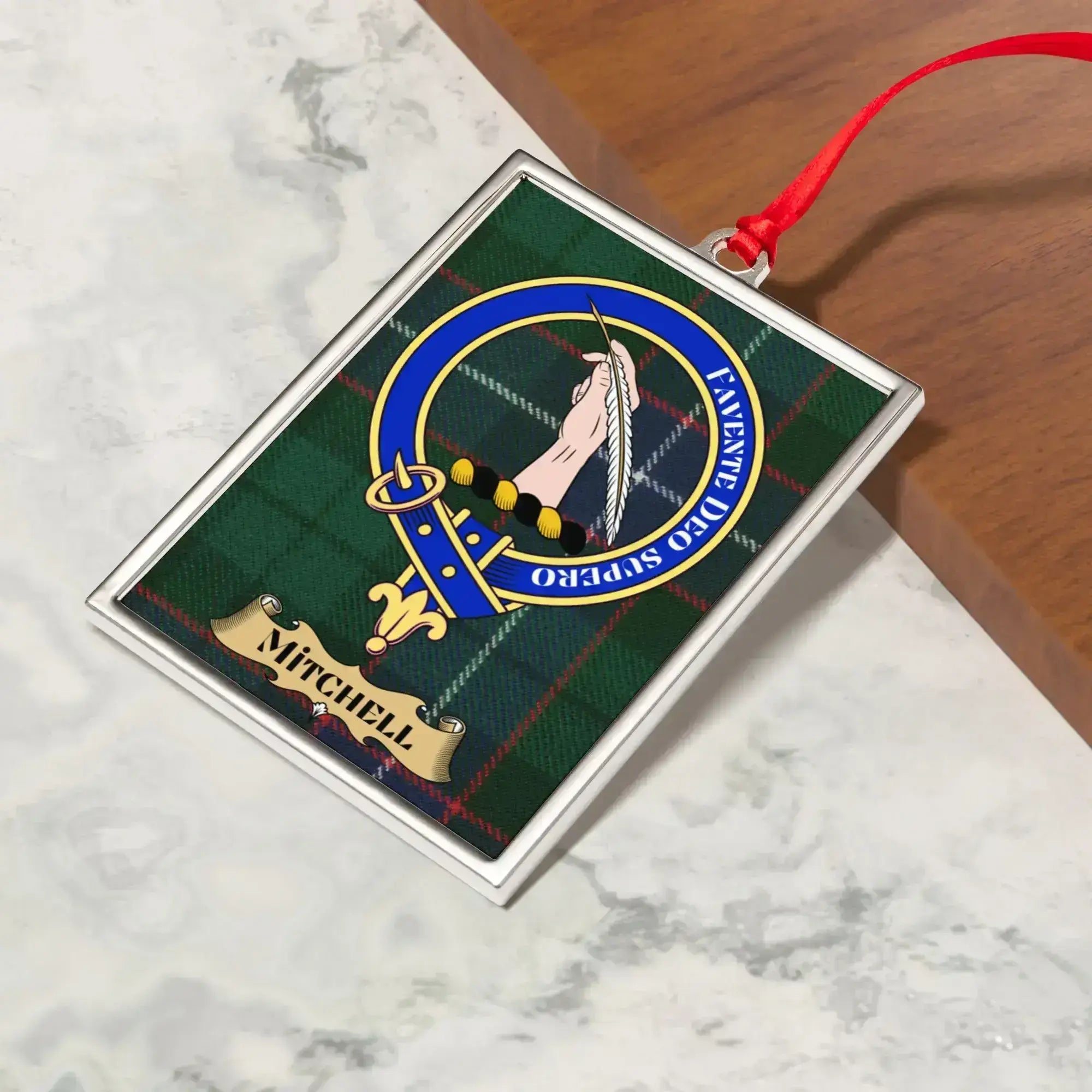 Mitchell ornament hanging from a Christmas tree branch by its satin ribbon