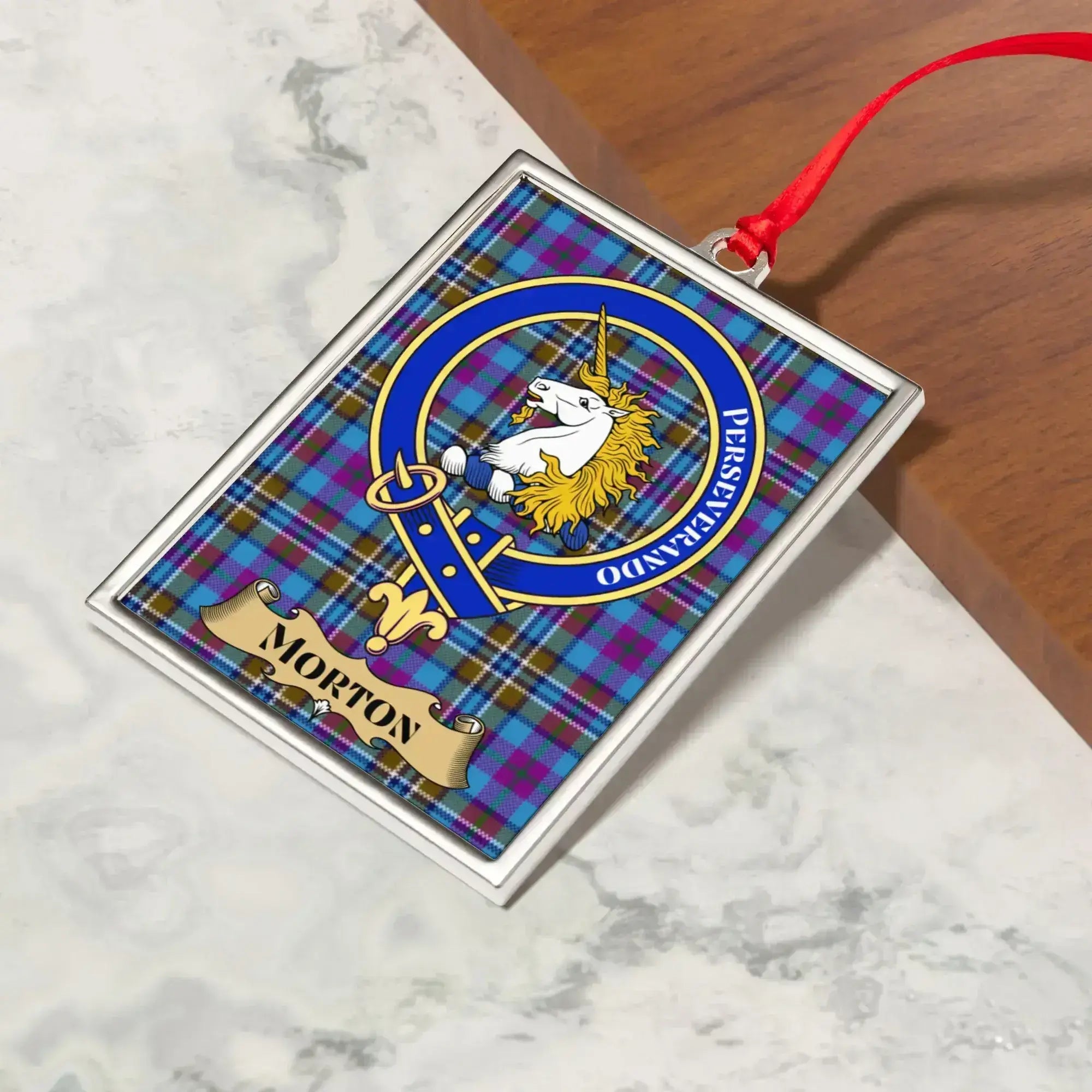 Morton ornament hanging from a Christmas tree branch by its satin ribbon