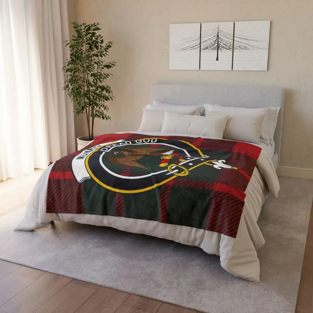 Munro clan crest tartan throw blanket on bed — printed polyester with white reverse and hemmed edges