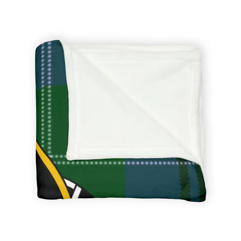 Oliphant tartan throw blanket on sofa — green and black plaid with clan crest