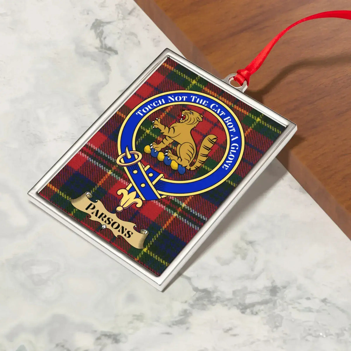 Parsons ornament hanging from a Christmas tree branch by its satin ribbon